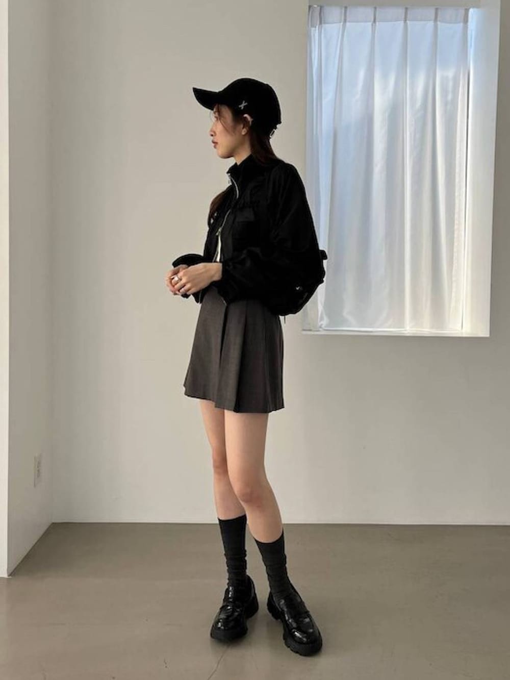 ブラック系のブルゾン、ブラック系のローファー、グレー系のスカートを着用したレディースの夏コーディネートの2枚目の写真