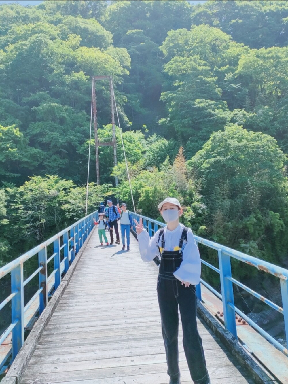 ホワイト系のシャツ/ブラウス、ブラック系のサロペット/オーバーオール、ブラック系のバックパック/リュックを着用したレディースの春コーディネートの2枚目の写真