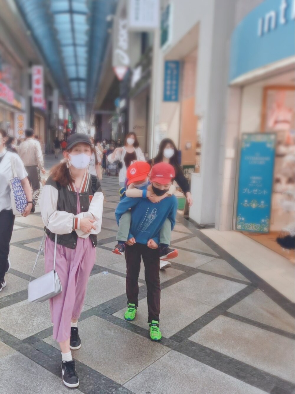 パープル系のワンピース、グリーン系のスタジャン、ブラック系のスニーカーを着用したレディースの夏コーディネートの2枚目の写真