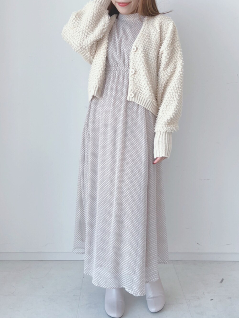 ホワイト系のカーディガン/ボレロ、ベージュ系のワンピース、ベージュ系のブーツを着用したレディースの秋コーディネートの2枚目の写真