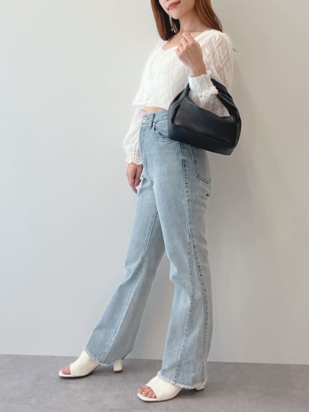 ホワイト系のサンダル、ブラック系のショルダーバッグ、ブルー系のデニムパンツを着用したレディースの春コーディネートの2枚目の写真