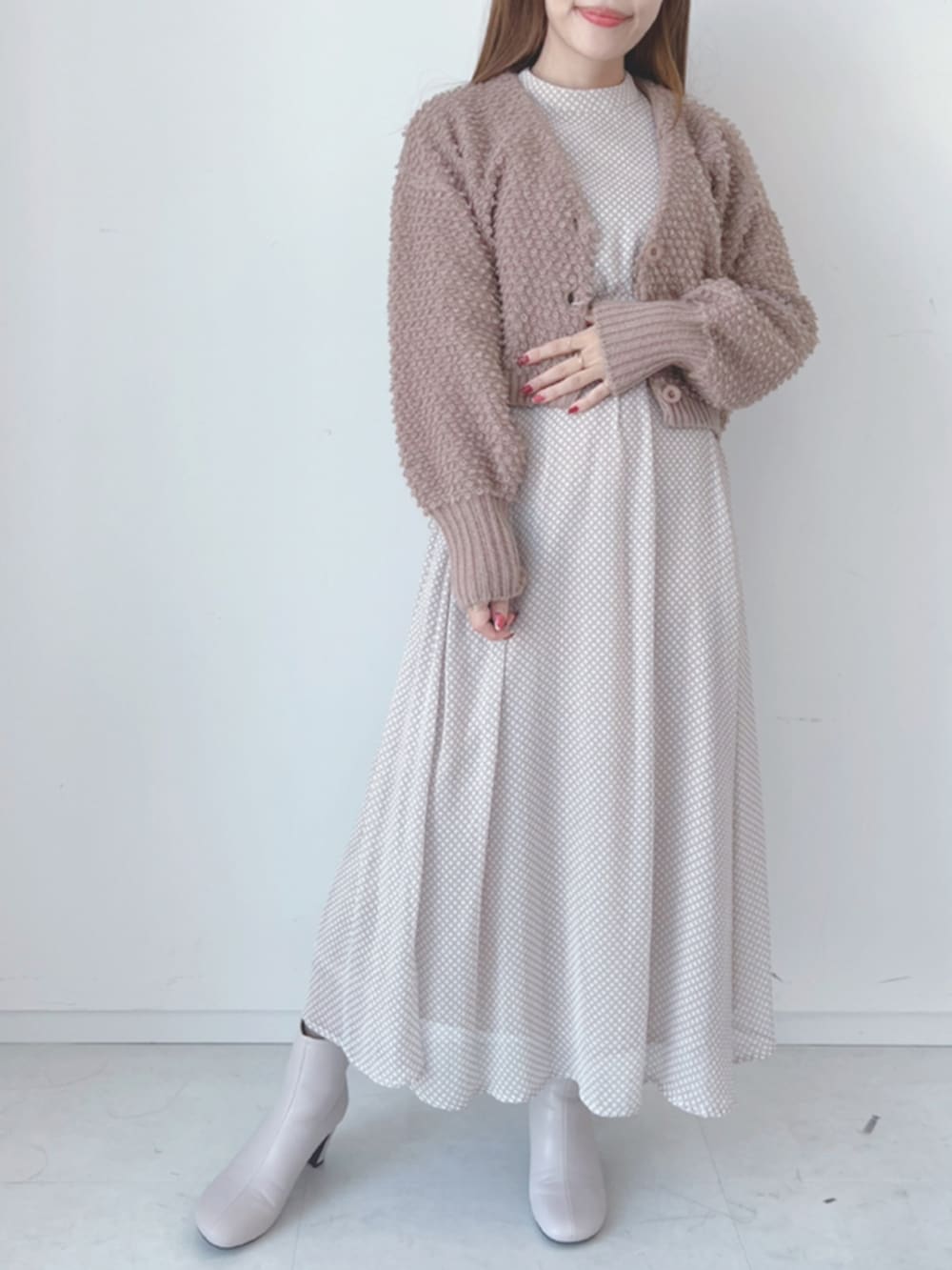 ベージュ系のブーツ、ベージュ系のワンピース、ブラウン系のカーディガン/ボレロを着用したレディースの秋コーディネートの3枚目の写真