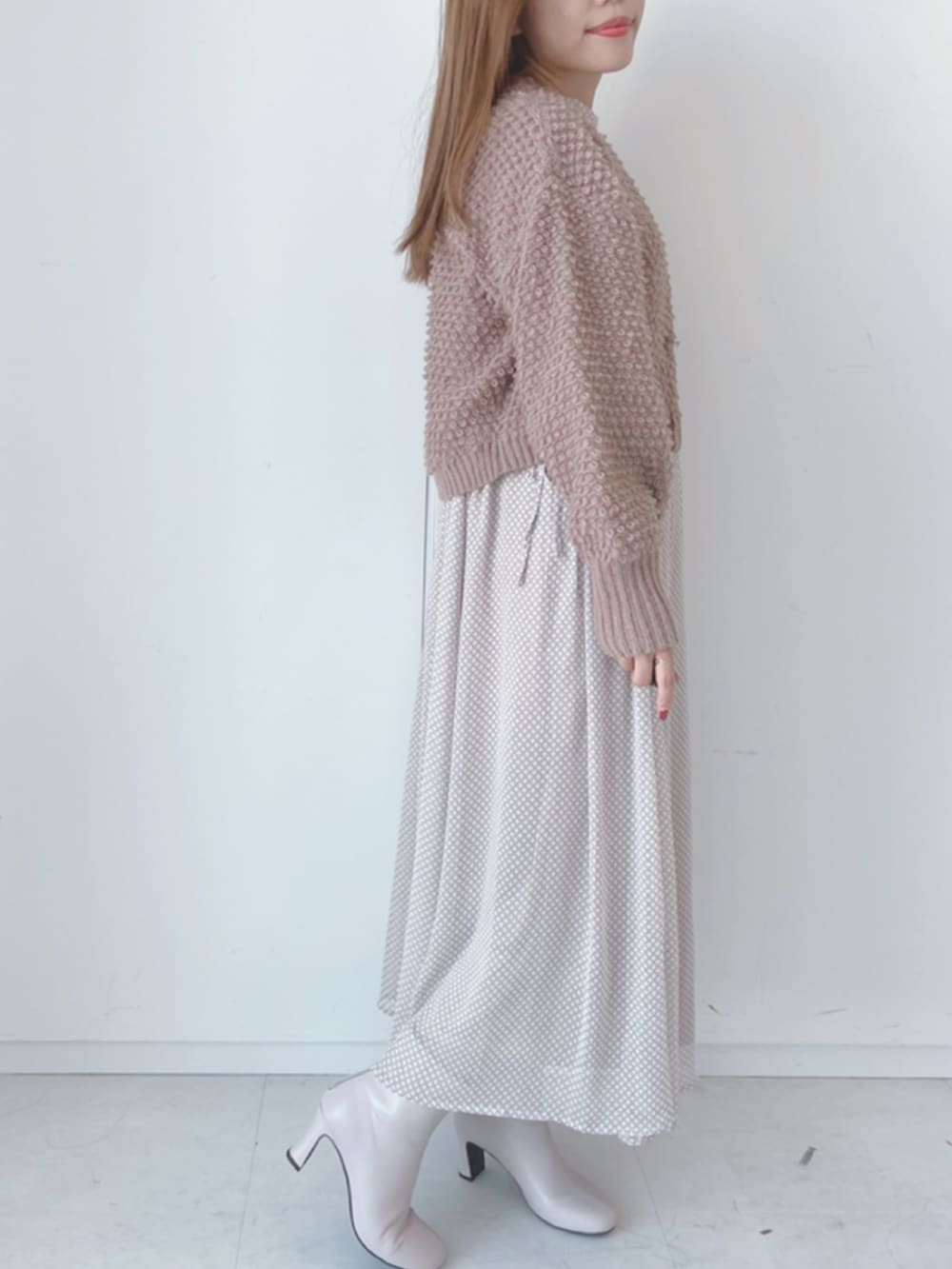 ベージュ系のブーツ、ベージュ系のワンピース、ブラウン系のカーディガン/ボレロを着用したレディースの秋コーディネートの2枚目の写真