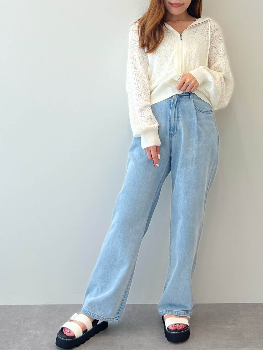 ブルー系のデニムパンツ、ホワイト系のカーディガン/ボレロ、ホワイト系のサンダルを着用したレディースの春コーディネートの2枚目の写真