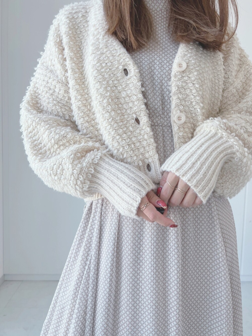 ホワイト系のカーディガン/ボレロ、ベージュ系のワンピース、ベージュ系のブーツを着用したレディースの秋コーディネートの3枚目の写真