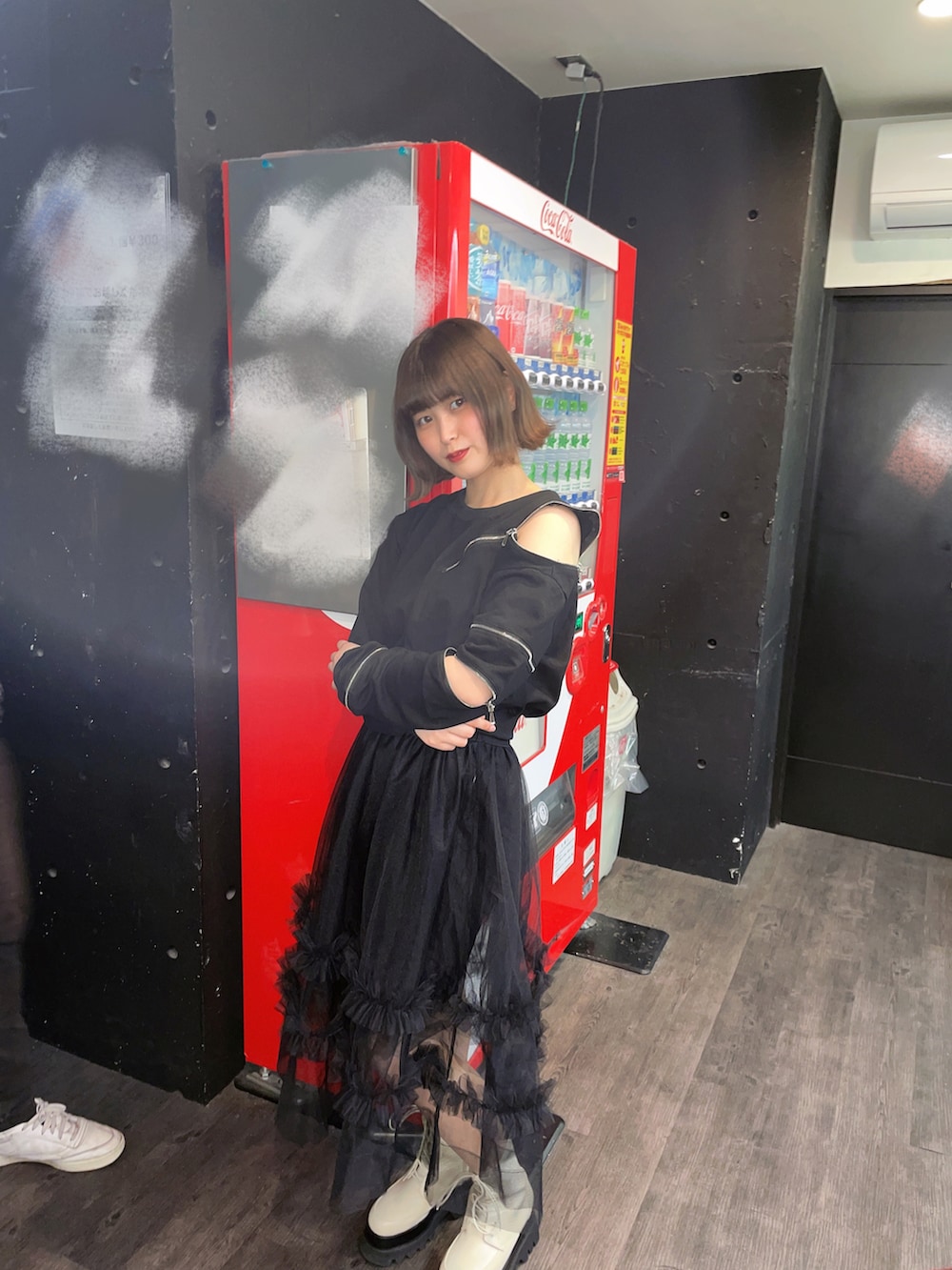 ブラック系のスウェット、ブラック系のスカート、ホワイト系のブーツを着用したレディースの春コーディネートの2枚目の写真