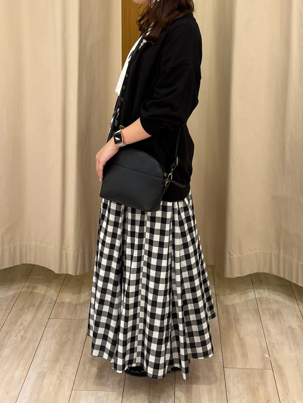 ブラック系のカーディガン/ボレロ、ホワイト系のTシャツ/カットソー、ブラック系のスカートを着用したレディースの春コーディネートの2枚目の写真