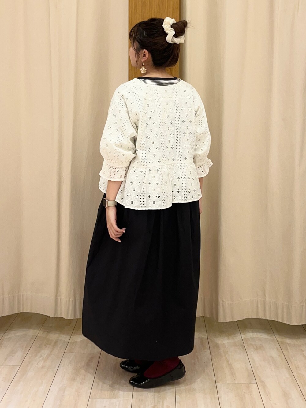 ブラック系のワンピース、ホワイト系のノーカラージャケットを着用したレディースの春コーディネートの2枚目の写真