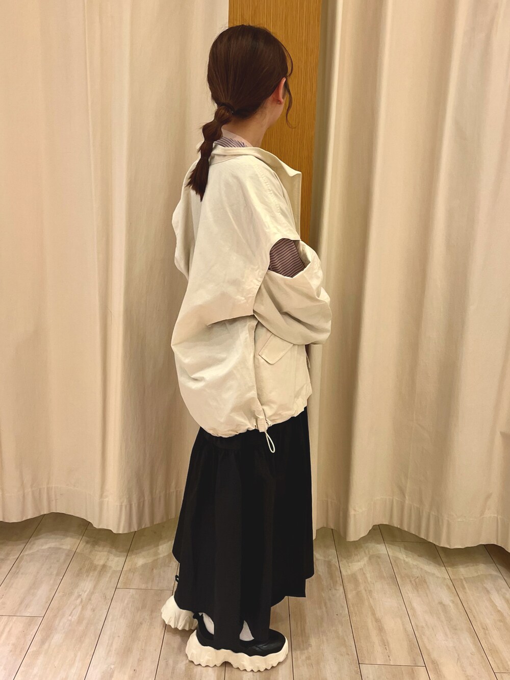 ブラック系のドレスシューズ、ブラック系のスカート、ホワイト系のノーカラージャケットを着用したレディースの春コーディネートの2枚目の写真