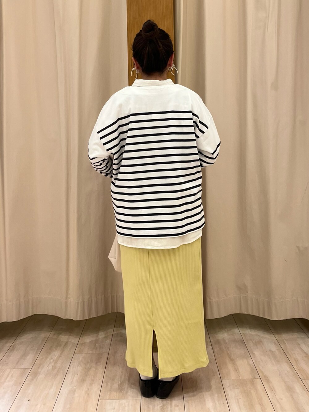 ブラック系のパンプス、イエロー系のスカート、ブルー系のTシャツ/カットソーを着用したレディースの春コーディネートの3枚目の写真