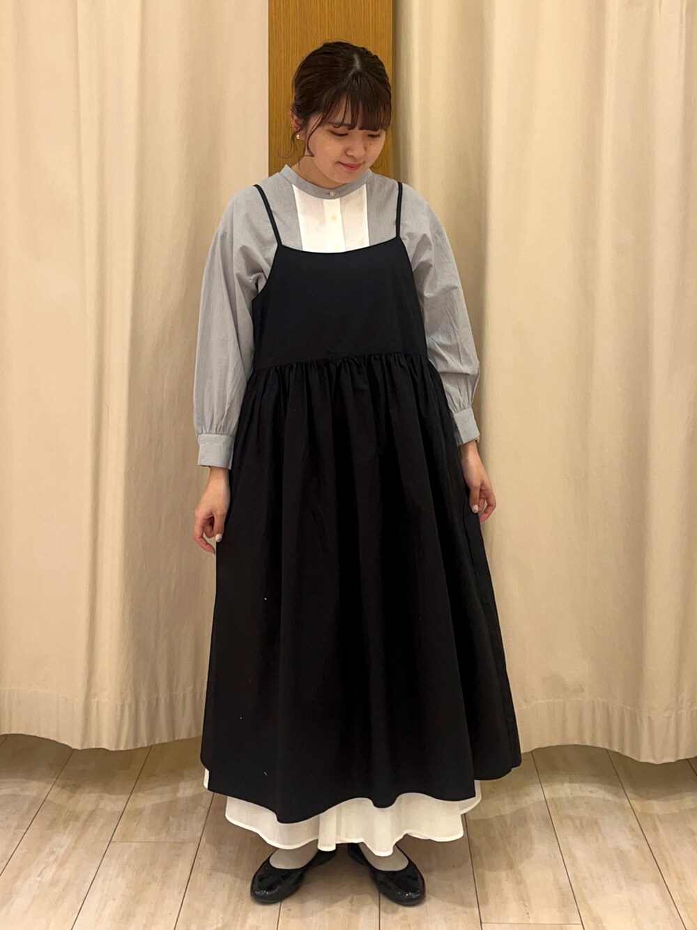 ブラック系のワンピース、ホワイト系のシャツ/ブラウスを着用したレディースの春コーディネートの2枚目の写真