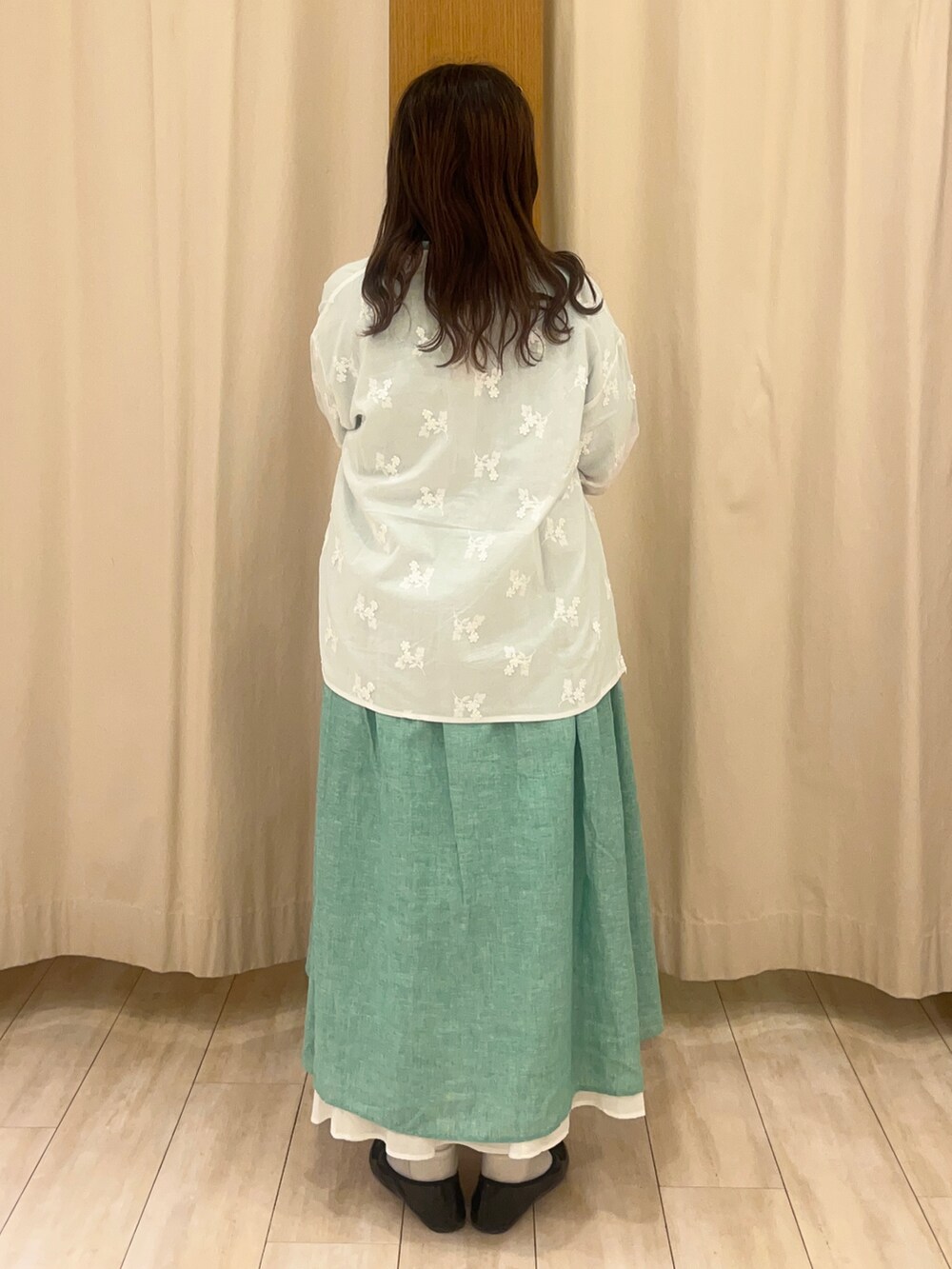 グリーン系のワンピース、ホワイト系のスカート、ホワイト系のシャツ/ブラウスを着用したレディースの春コーディネートの2枚目の写真