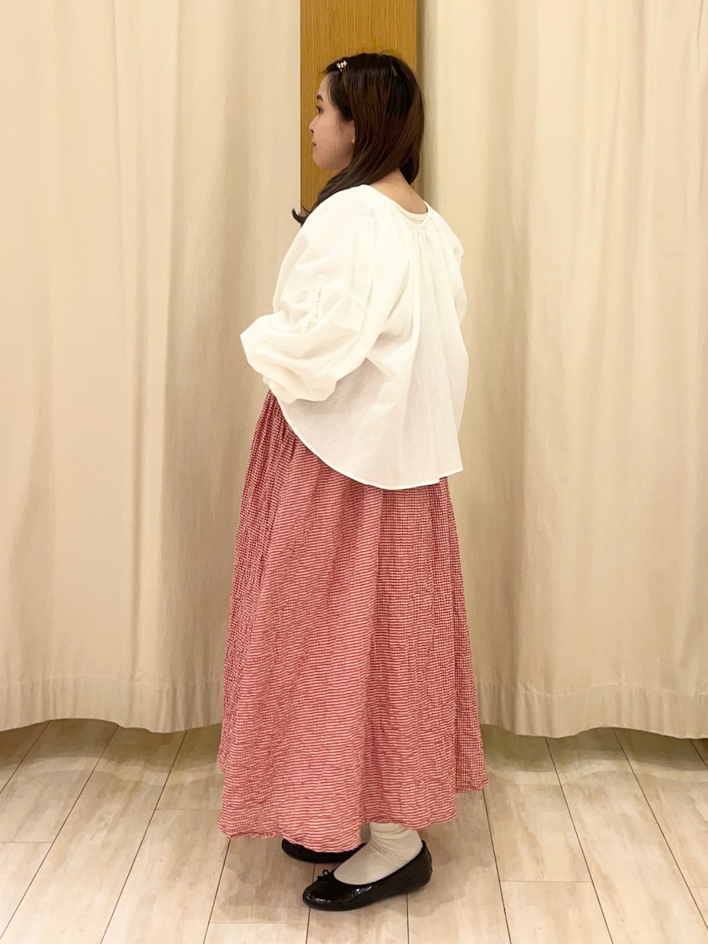 ホワイト系のシャツ/ブラウス、レッド系のワンピース、ホワイト系のスカートを着用したレディースの春コーディネートの2枚目の写真