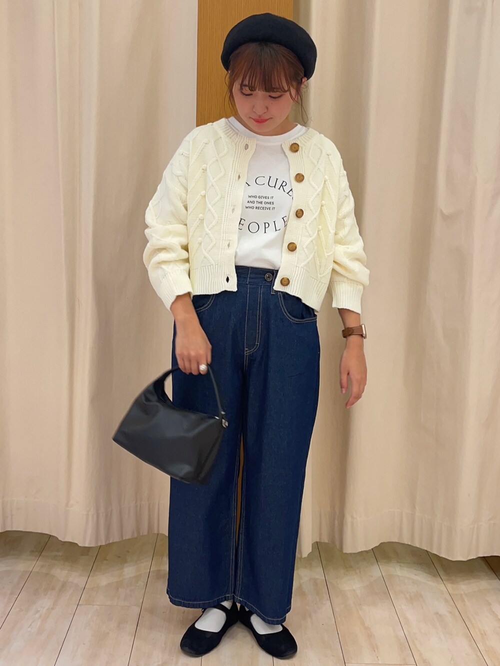 ブルー系のデニムパンツ、ブラック系のショルダーバッグ、ホワイト系のカーディガン/ボレロを着用したレディースの秋コーディネートの2枚目の写真