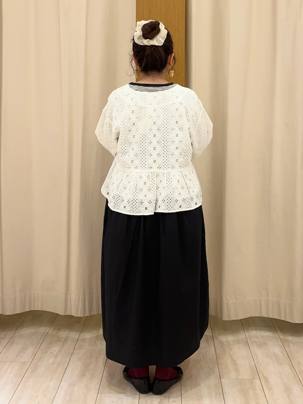 ブラック系のワンピース、ホワイト系のノーカラージャケットを着用したレディースの春コーディネートの3枚目の写真