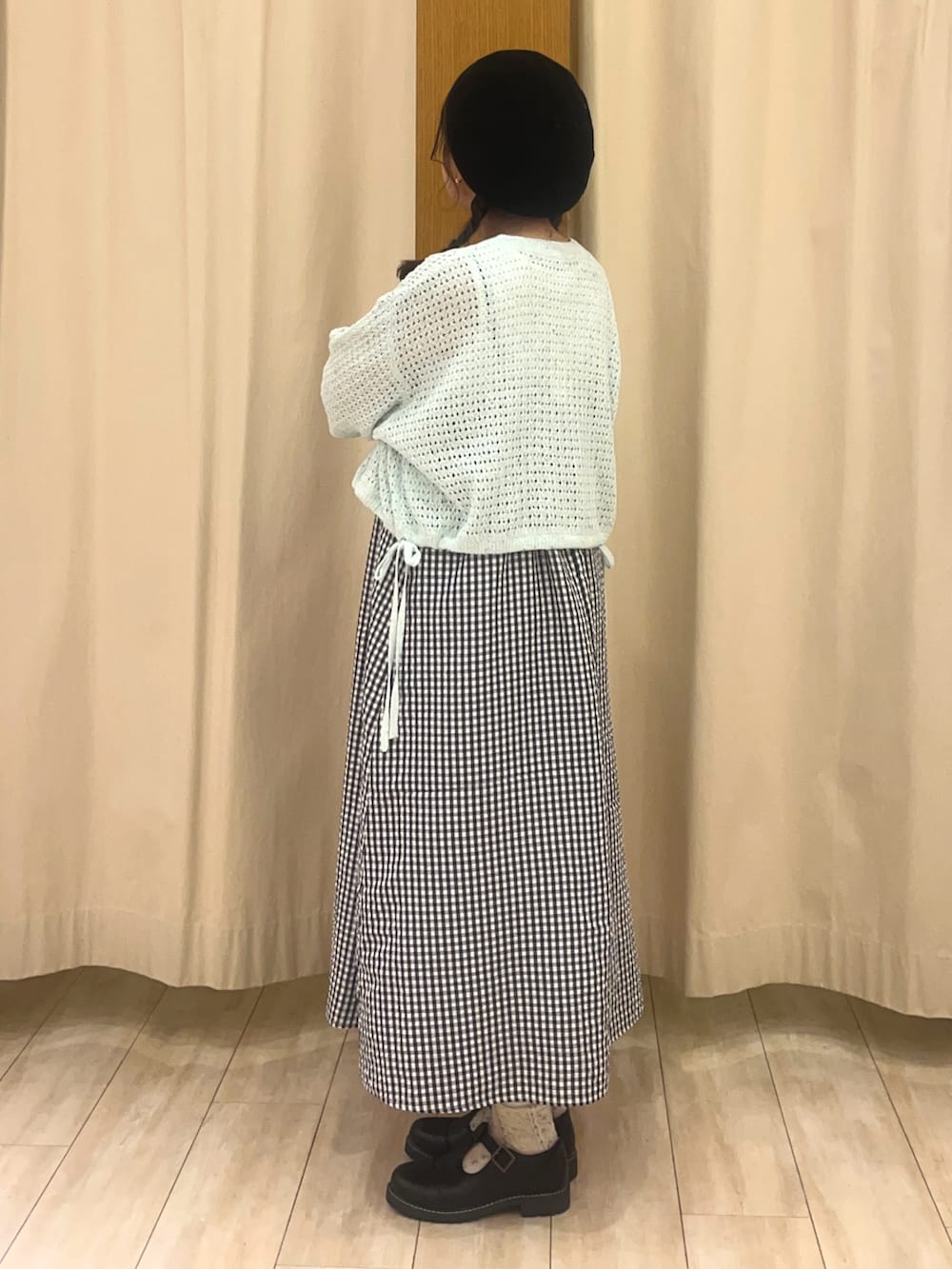 ブラック系のその他シューズ、ホワイト系のワンピース、グリーン系のカーディガン/ボレロを着用したレディースの春コーディネートの2枚目の写真