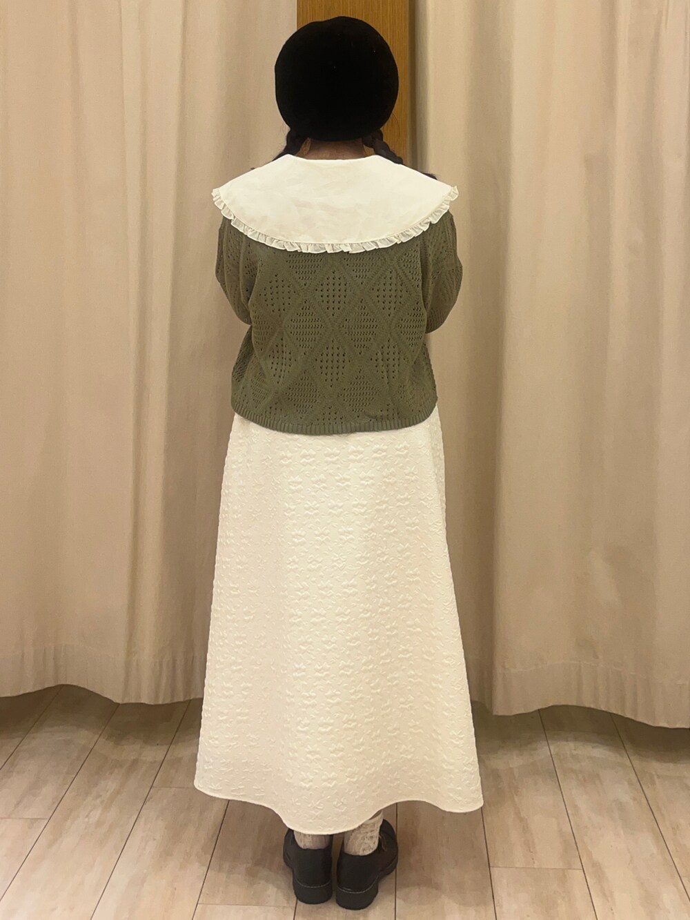 ブラック系のその他シューズ、ホワイト系のスカート、グリーン系のカーディガン/ボレロを着用したレディースの春コーディネートの3枚目の写真