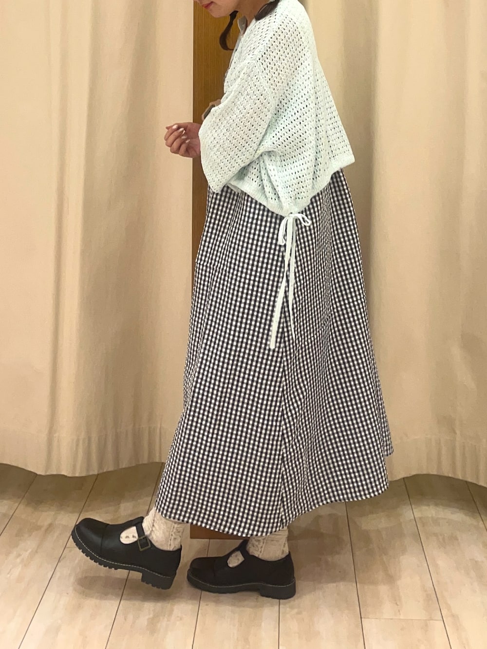 ブラック系のその他シューズ、ホワイト系のワンピース、グリーン系のカーディガン/ボレロを着用したレディースの春コーディネートの3枚目の写真