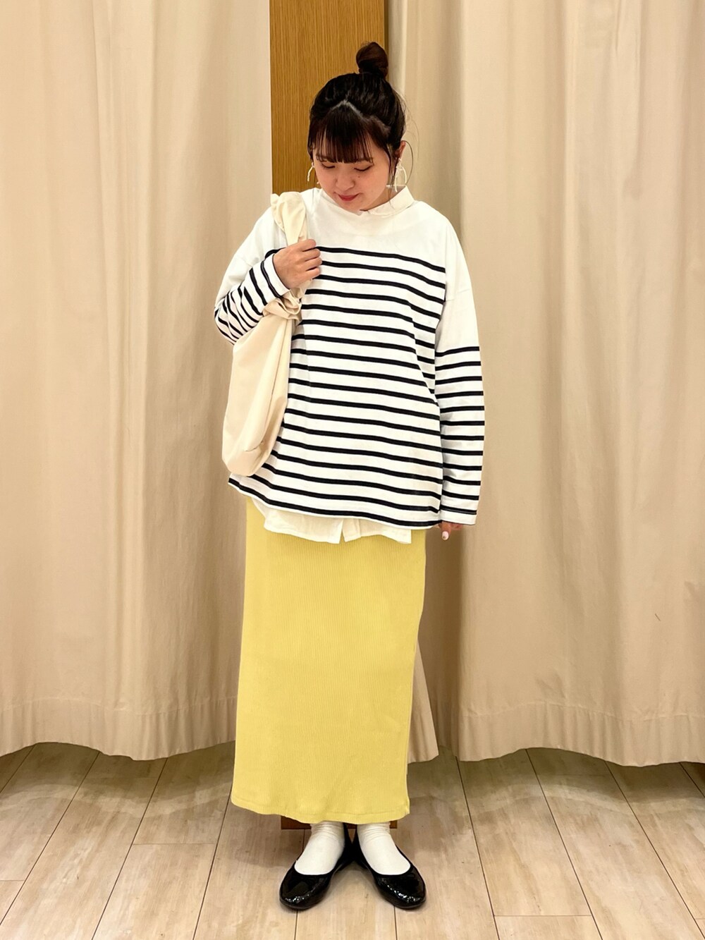 ブラック系のパンプス、イエロー系のスカート、ブルー系のTシャツ/カットソーを着用したレディースの春コーディネートの2枚目の写真