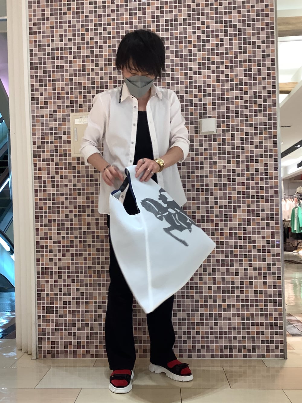 ホワイト系のバッグ、ブラック系のサンダル、ブラック系のデニムパンツを着用したメンズの夏コーディネートの2枚目の写真