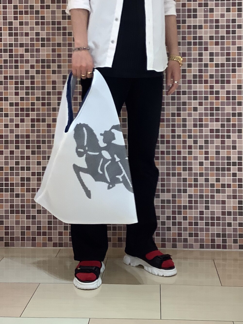 ホワイト系のバッグ、ブラック系のサンダル、ブラック系のデニムパンツを着用したメンズの夏コーディネートの3枚目の写真