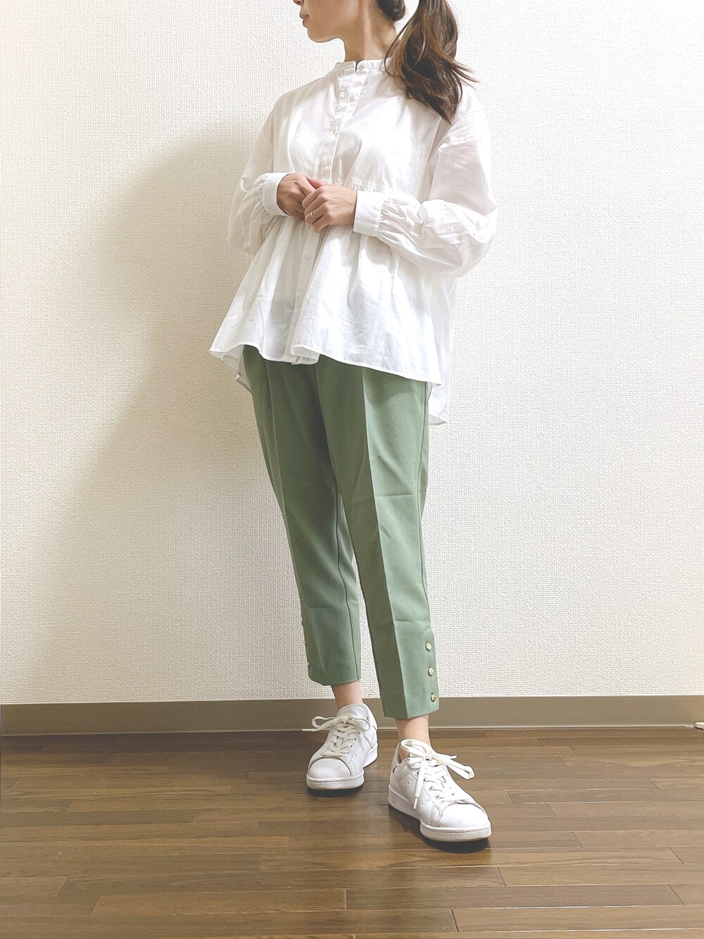 グリーン系のスラックス、ホワイト系のシャツ/ブラウス、ホワイト系のスニーカーを着用したレディースの春コーディネートの2枚目の写真