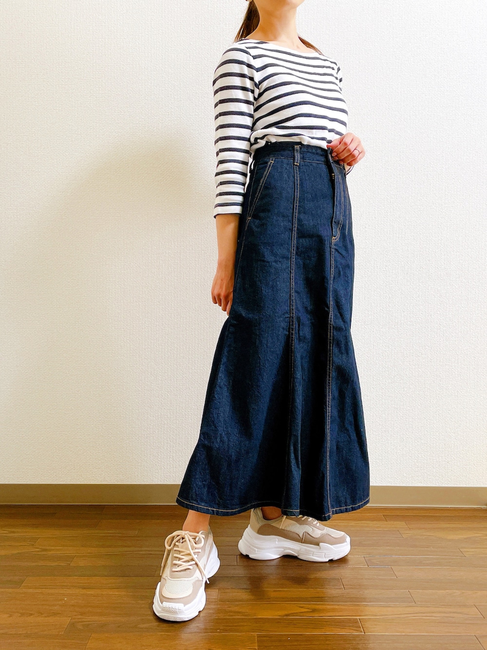 ブルー系のデニムスカート、ベージュ系のスニーカー、その他のTシャツ/カットソーを着用したレディースの春コーディネートの2枚目の写真