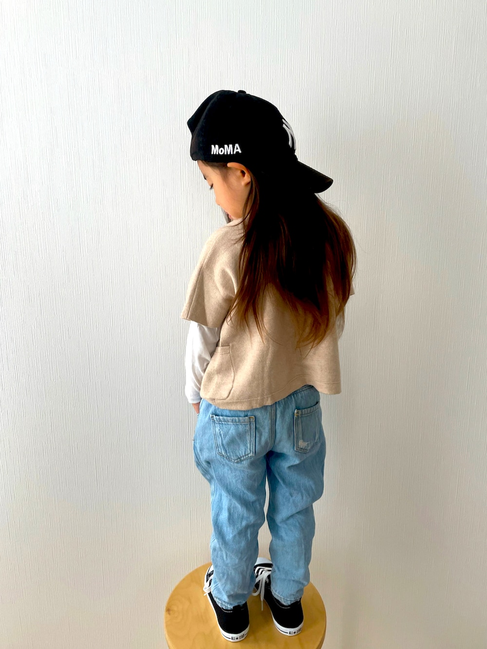 ベージュ系のニット/セーター、ブルー系のデニムパンツ、ブラック系のスニーカーを着用したキッズの春コーディネートの3枚目の写真