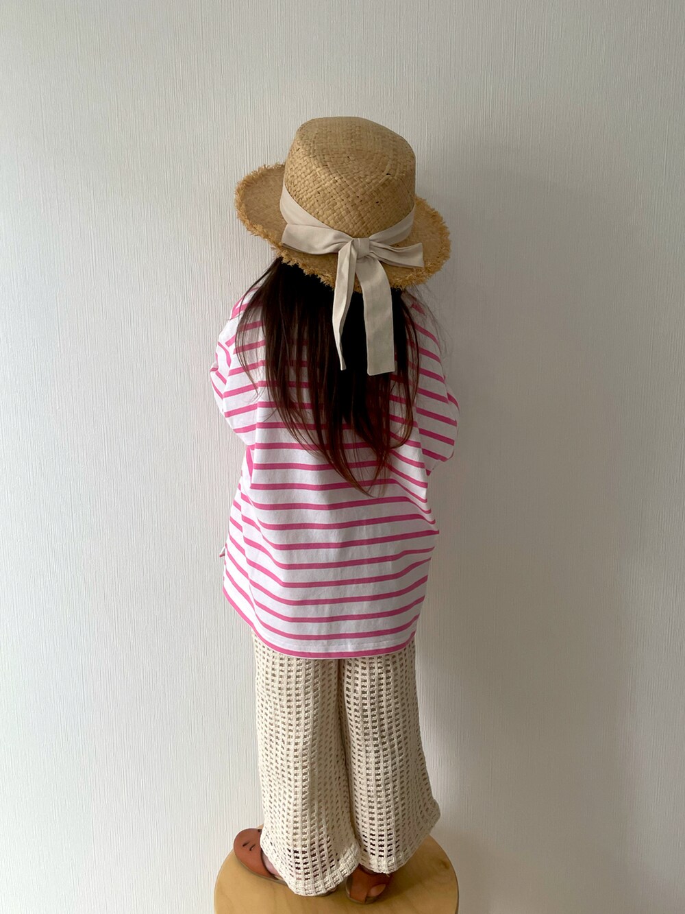 ピンク系のTシャツ/カットソー、ベージュ系のパンツ、ブラウン系のサンダルを着用したキッズの春コーディネートの3枚目の写真