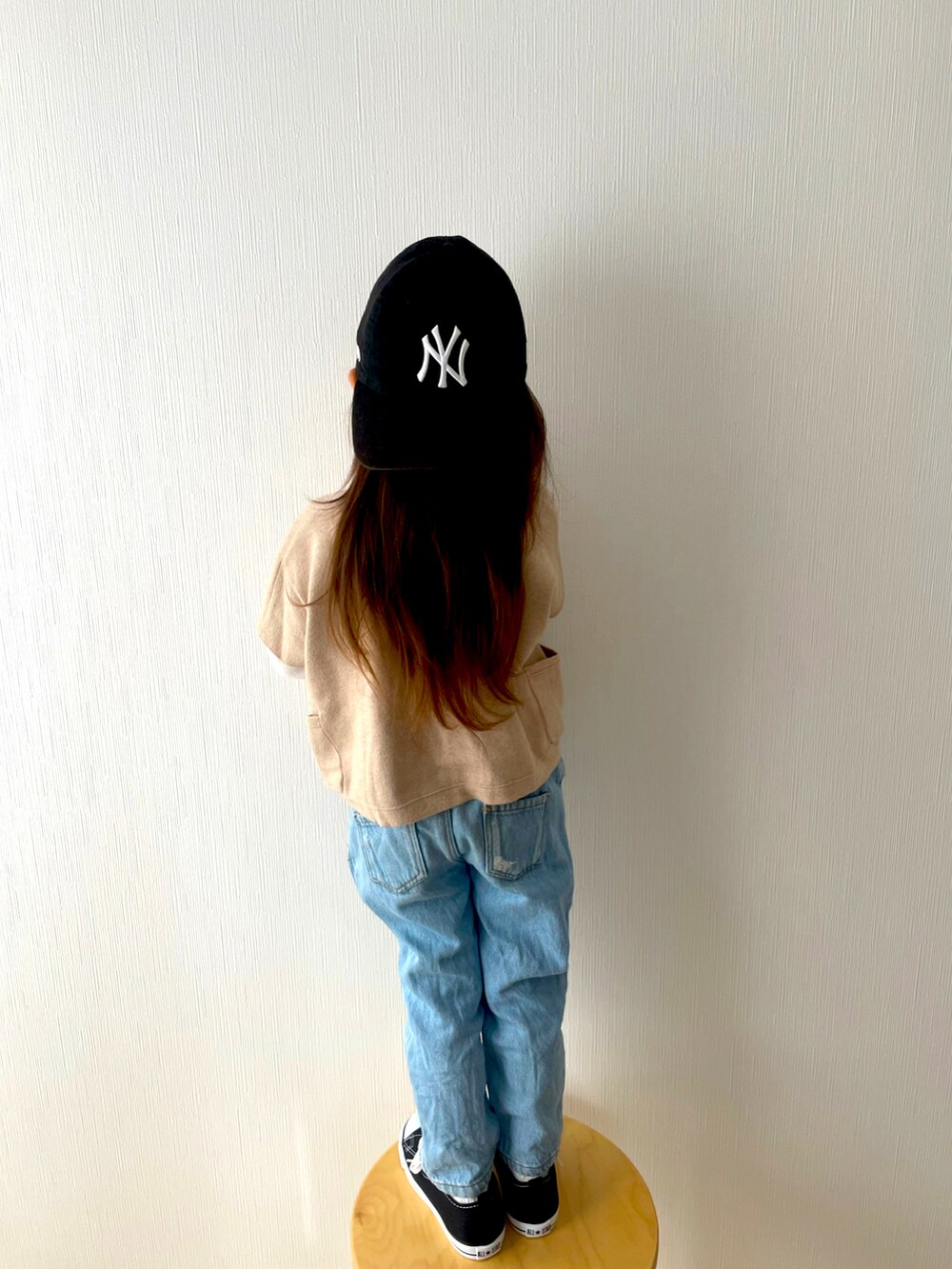 ベージュ系のニット/セーター、ブルー系のデニムパンツ、ブラック系のスニーカーを着用したキッズの春コーディネートの4枚目の写真