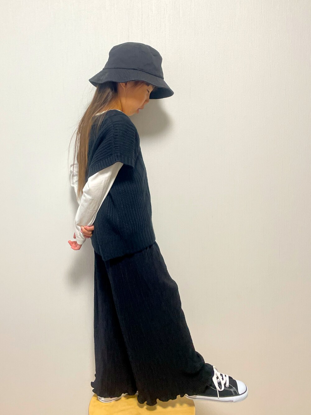 ブラック系のベスト、ブラック系のパンツ、ブラック系のスニーカーを着用したキッズの春コーディネートの2枚目の写真