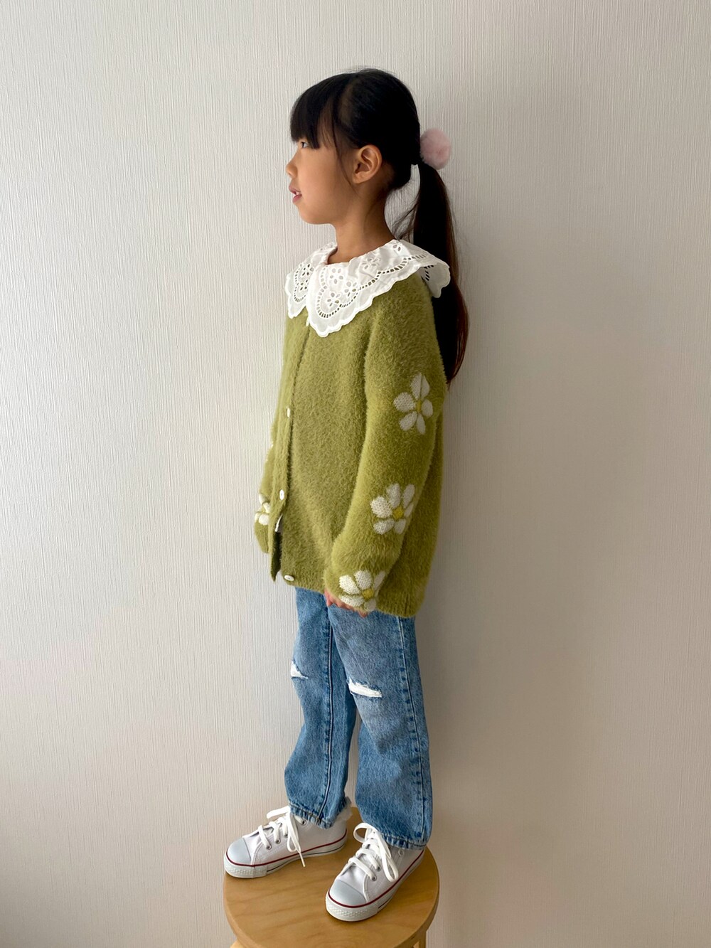 グリーン系のニット/セーター、ブルー系のデニムパンツ、ホワイト系のスニーカーを着用したキッズの冬コーディネートの3枚目の写真