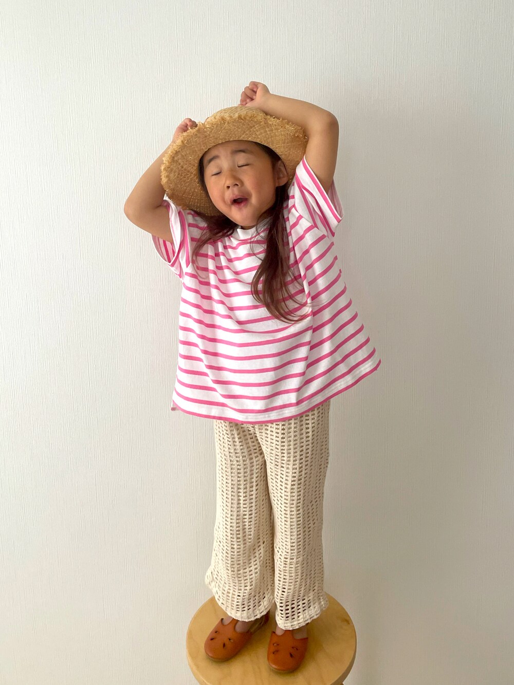 ピンク系のTシャツ/カットソー、ベージュ系のパンツ、ブラウン系のサンダルを着用したキッズの春コーディネートの4枚目の写真