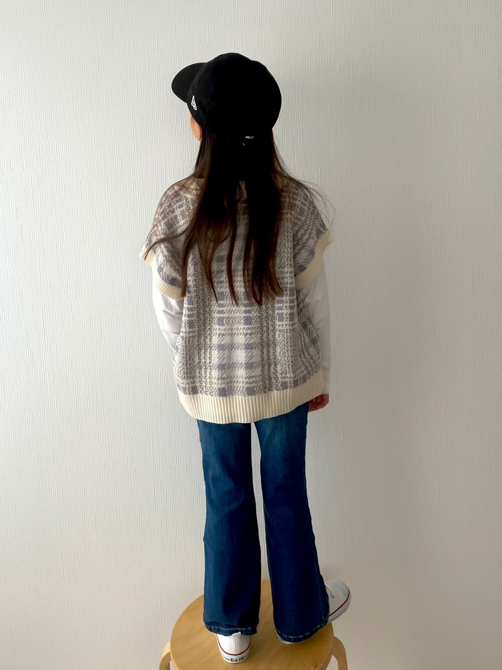 ホワイト系のスニーカー、ブルー系のデニムパンツ、その他のベストを着用したキッズの春コーディネートの2枚目の写真