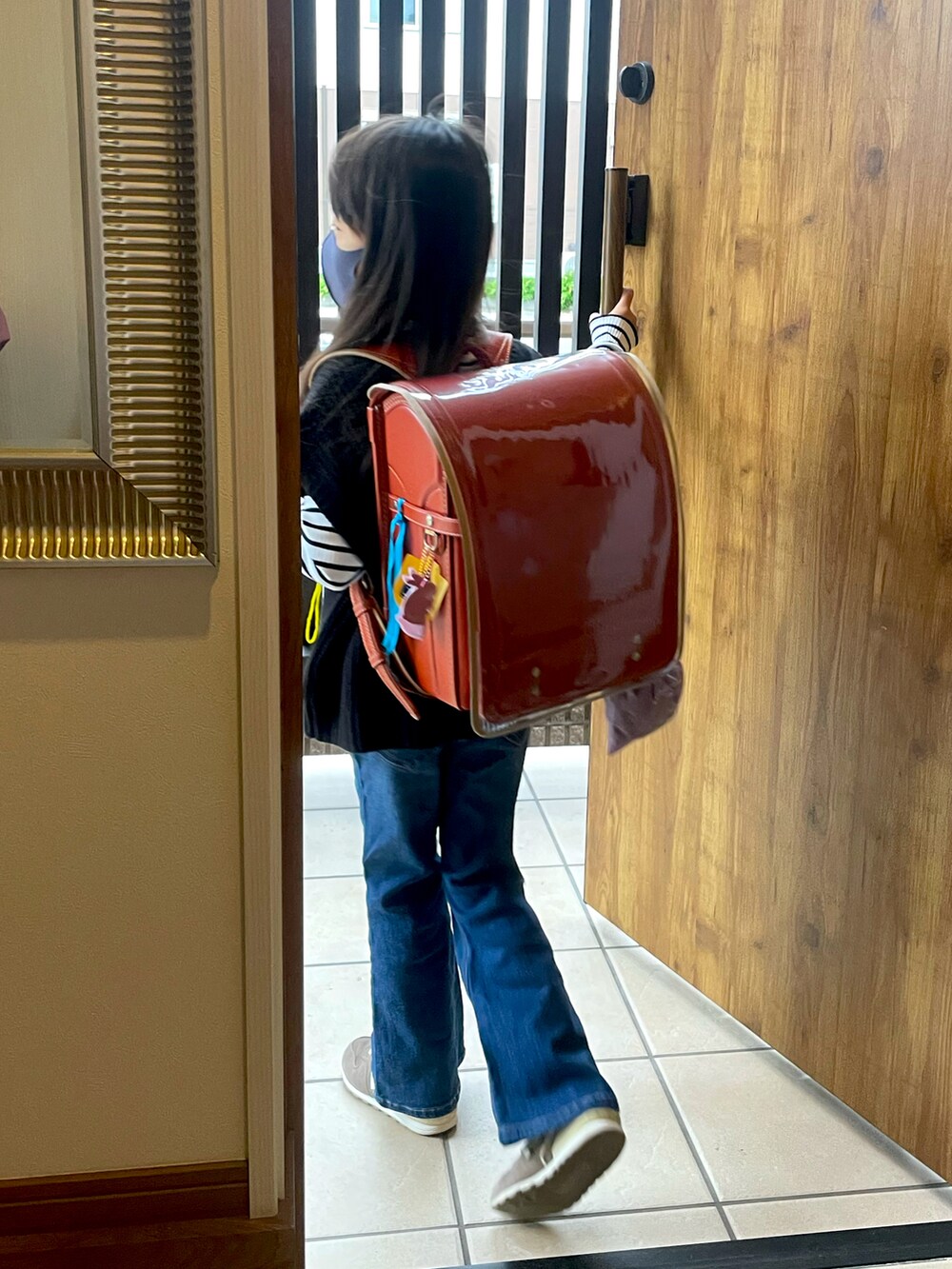 ブラック系のベスト、ブルー系のデニムパンツ、ピンク系のスニーカーを着用したキッズの春コーディネートの3枚目の写真