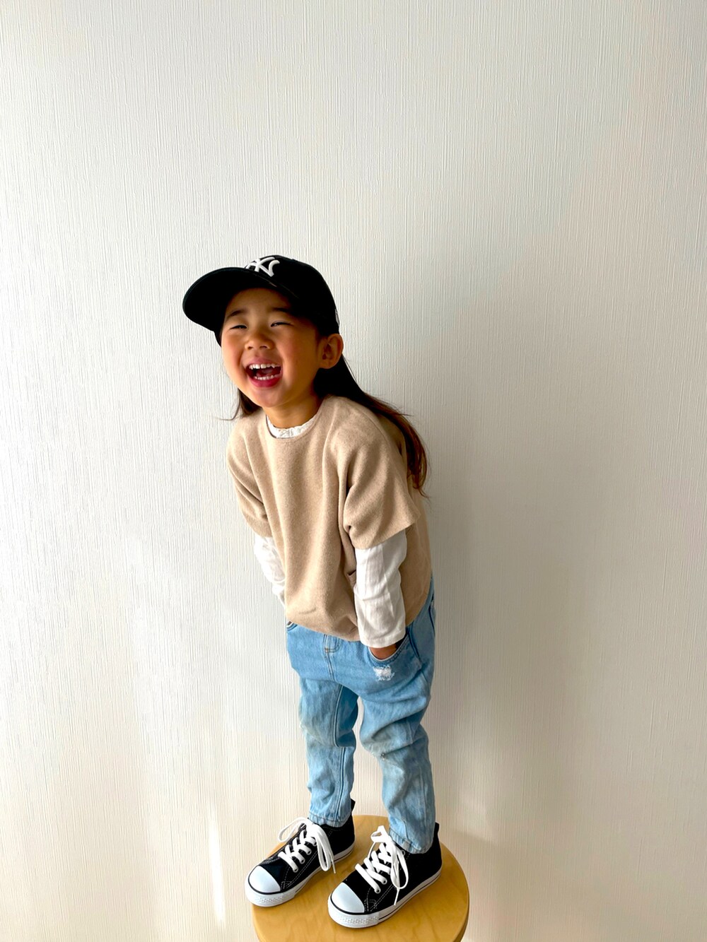 ベージュ系のニット/セーター、ブルー系のデニムパンツ、ブラック系のスニーカーを着用したキッズの春コーディネートの2枚目の写真