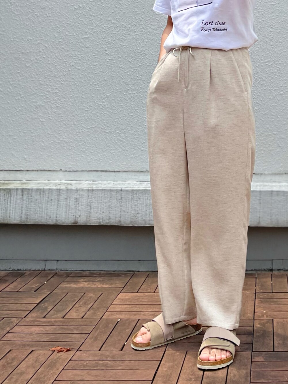 ベージュ系のその他パンツ、ホワイト系のTシャツ/カットソー、ベージュ系のサンダルを着用したメンズの夏コーディネートの3枚目の写真