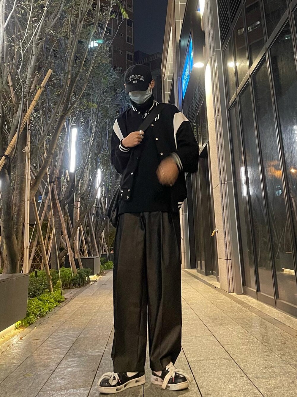 ブラック系のその他アウター、ブラック系のスニーカー、ブラック系のキャップを着用したメンズの春コーディネートの2枚目の写真