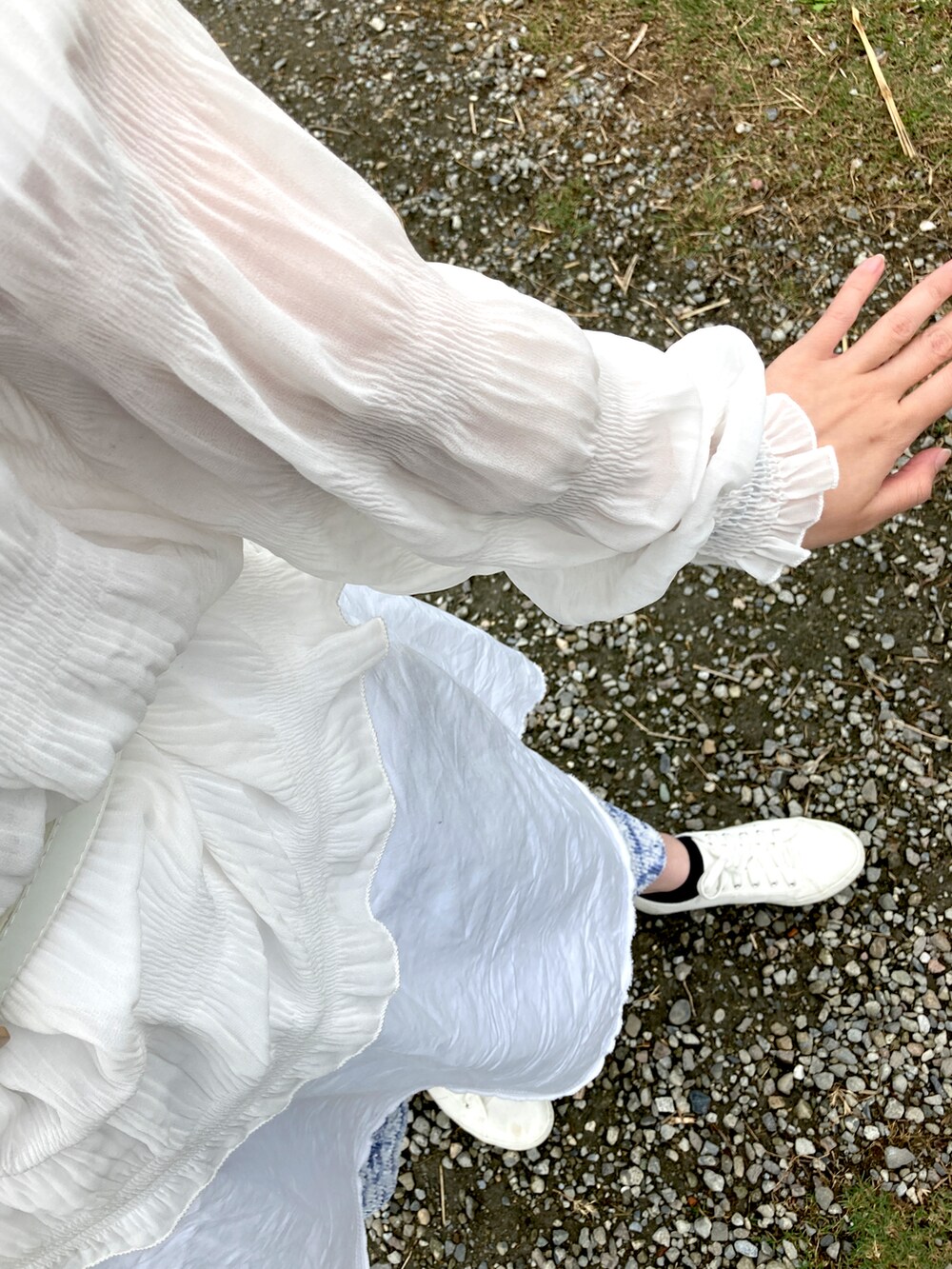 ブルー系のチノパンツ、ホワイト系のスリッポン、グリーン系のショルダーバッグを着用したレディースの春コーディネートの2枚目の写真