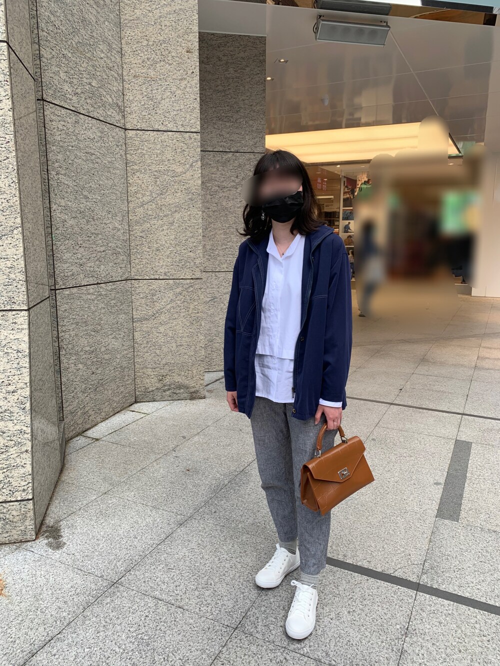 ホワイト系のシャツ/ブラウス、ホワイト系のスリッポン、ブラウン系のショルダーバッグを着用したレディースの春コーディネートの2枚目の写真