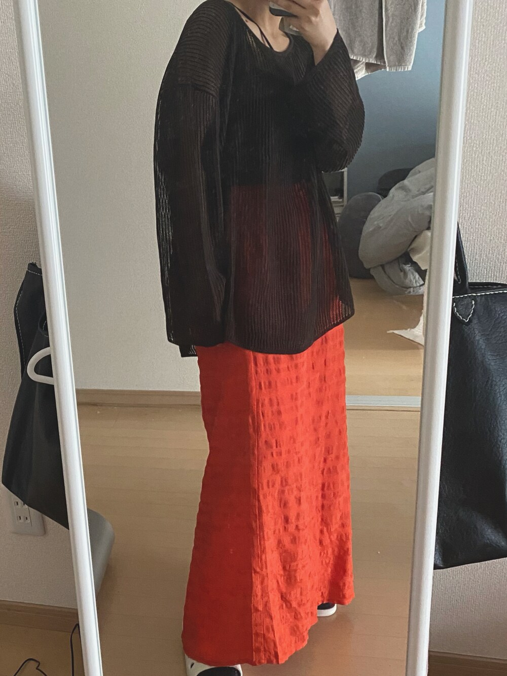 ブラウン系のトップス、ブラック系のキャミソール、オレンジ系のスカートを着用したレディースの春コーディネートの2枚目の写真