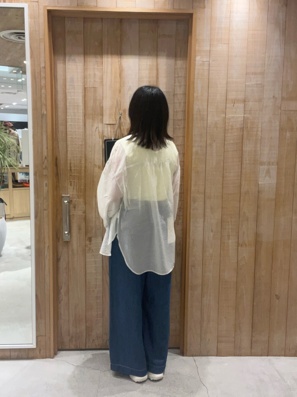 イエロー系のタンクトップ、グレー系のシャツ/ブラウス、ブルー系のデニムパンツを着用したレディースの夏コーディネートの3枚目の写真