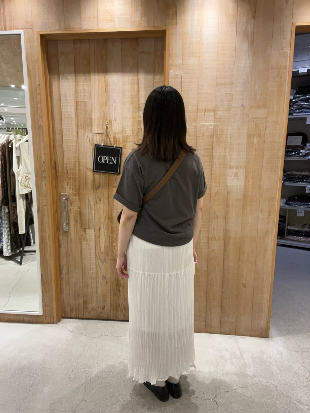 ホワイト系のTシャツ/カットソー、ブルー系のスカート、ブラウン系のショルダーバッグを着用したレディースの夏コーディネートの3枚目の写真
