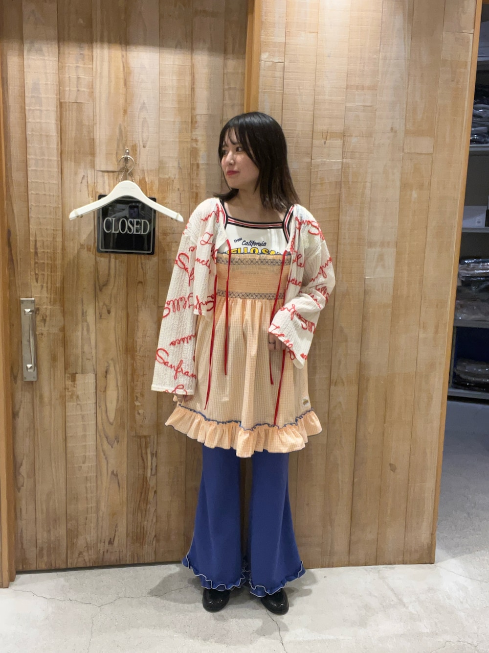 オレンジ系のワンピース、ホワイト系のTシャツ/カットソー、ホワイト系のキャミソールを着用したレディースの夏コーディネートの2枚目の写真