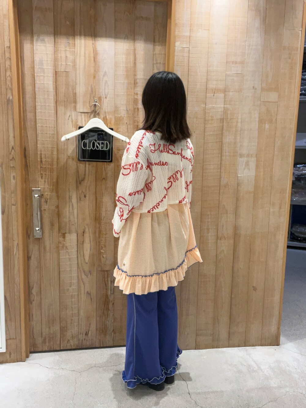 オレンジ系のワンピース、ホワイト系のTシャツ/カットソー、ホワイト系のキャミソールを着用したレディースの夏コーディネートの3枚目の写真