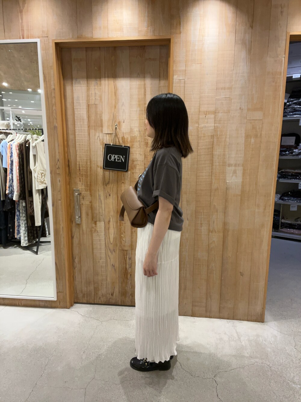 ホワイト系のTシャツ/カットソー、ブルー系のスカート、ブラウン系のショルダーバッグを着用したレディースの夏コーディネートの2枚目の写真