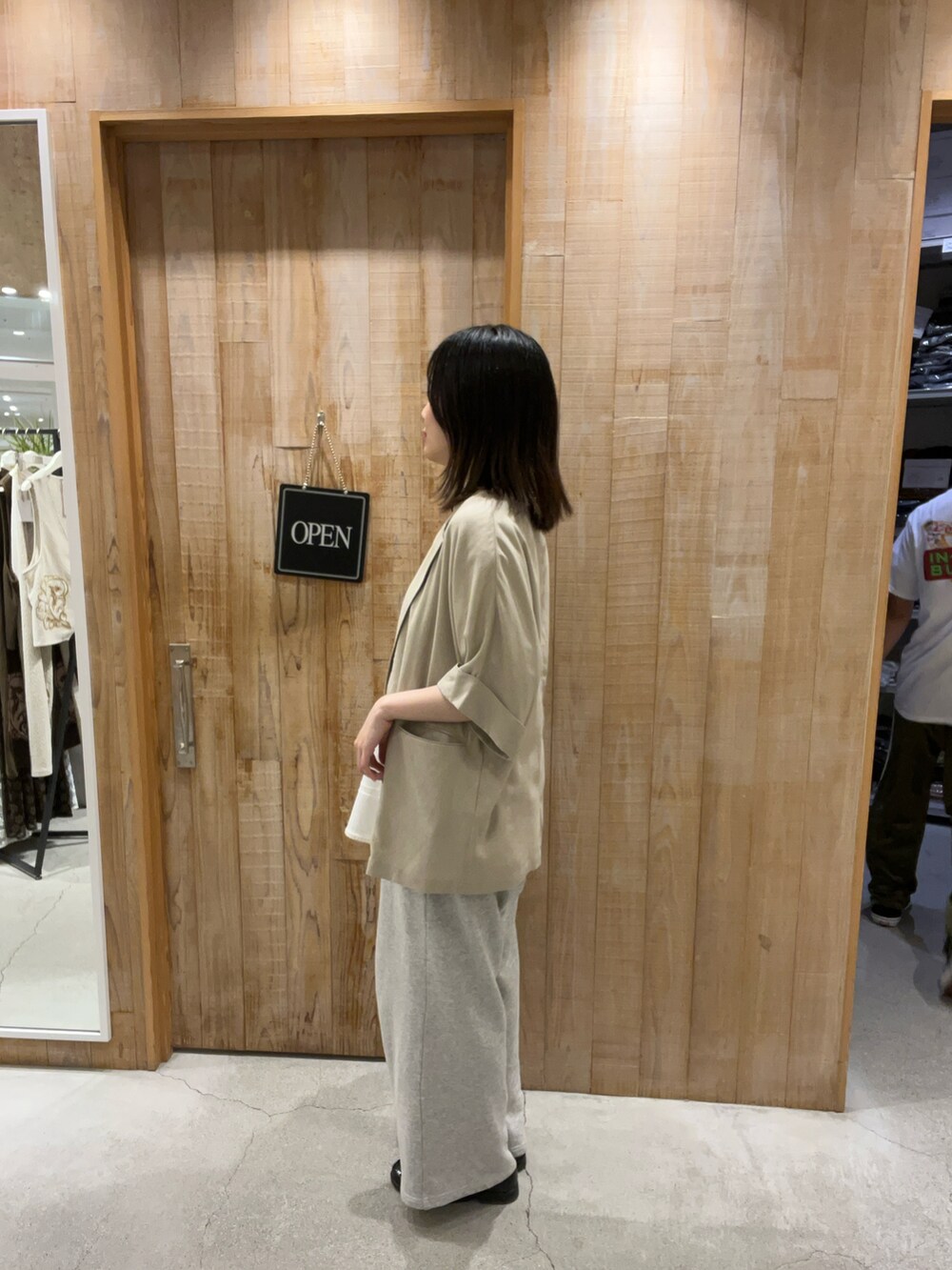 ホワイト系のTシャツ/カットソー、ベージュ系のテーラードジャケット、ホワイト系のスカートを着用したレディースの夏コーディネートの2枚目の写真