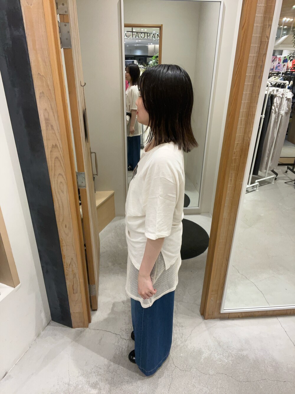 ホワイト系のTシャツ/カットソー、ブラック系のチュニック、ブルー系のデニムパンツを着用したレディースの夏コーディネートの2枚目の写真