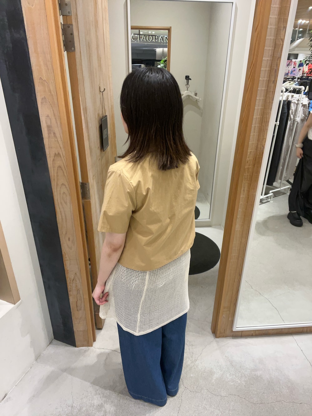 ブラック系のチュニック、ブルー系のデニムパンツ、ベージュ系のその他アウターを着用したレディースの夏コーディネートの3枚目の写真