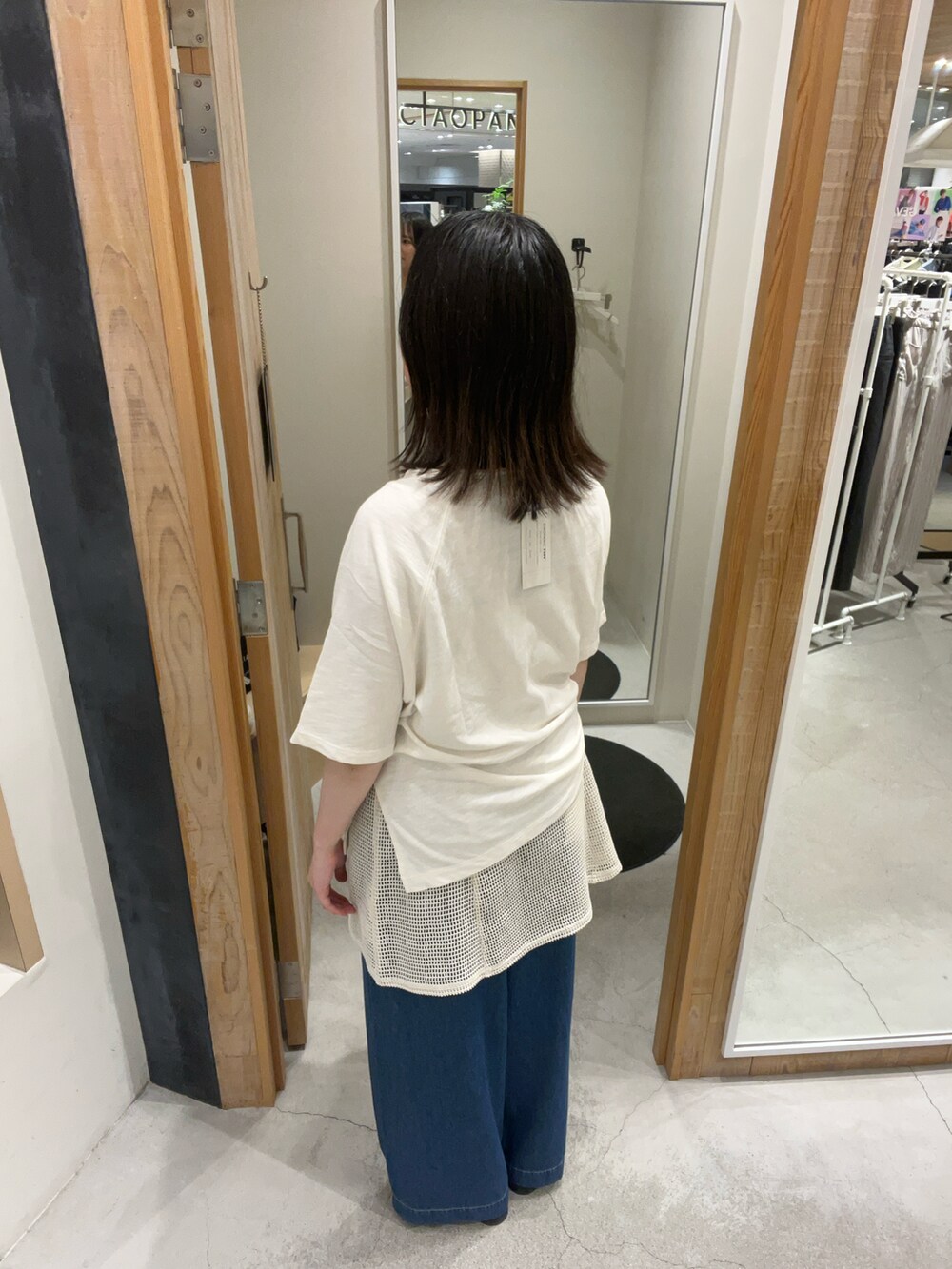 ホワイト系のTシャツ/カットソー、ブラック系のチュニック、ブルー系のデニムパンツを着用したレディースの夏コーディネートの3枚目の写真